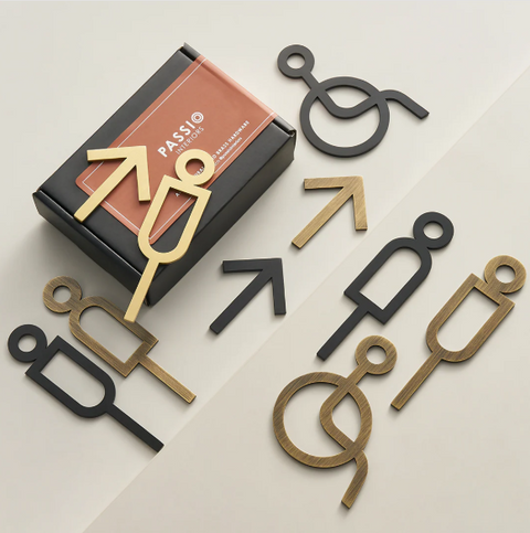 High-quality solid brass bathroom and accessibility signage in black, showcasing tactile letters and symbols, designed for durability, ADA compliance, and a sleek, modern appearance.