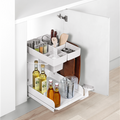 Peka Kitchen Tower white pull-out caddy in a white kitchen cabinet, holding oil bottles, spice jars and utensils