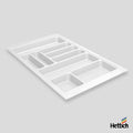 A white plastic organizer tray with multiple compartments, shown at an angle on a light gray background with the Hettich brand logo in the bottom right corner.