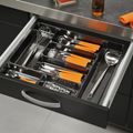 Häfele Excel utensil tray fitted in an open kitchen drawer, its wide compartments holding a whisk, ladle, grater and cutlery