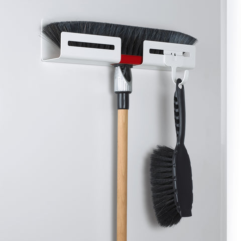 Peka Libell white broom holder mounted on a door, holding a broom and dustpan brush