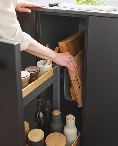 Close-up of Peka Pinello Board anthracite pull-out with a wooden chopping board being lifted from the integrated rack