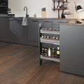 Peka Pinello Spice anthracite narrow pull-out extended from a dark kitchen cabinet, organising oil bottles and jars