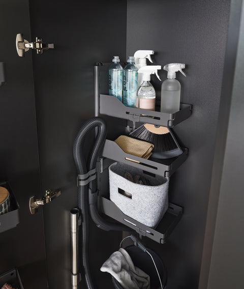 Peka Sesam Standard anthracite cleaning cupboard shelving system holding spray bottles, cloths, a vacuum hose and a basket