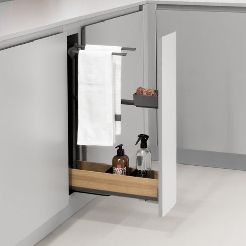 Peka Snello anthracite towel rail extension pull-out with towel rail and tray holding towels and cleaning bottles in a grey kitchen cabinet