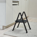 Peka Stepolo compact one-step folding stepladder in black, unfolded on a kitchen floor