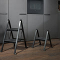 Peka Stepolo folding stepladders, the taller two-step and shorter one-step models in black, in a modern kitchen