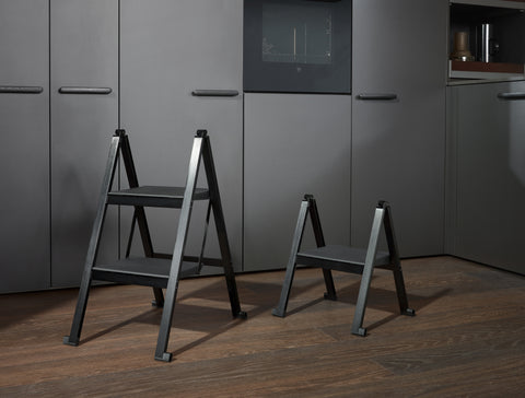 Peka Stepolo folding stepladders, the taller two-step and shorter one-step models in black, in a modern kitchen