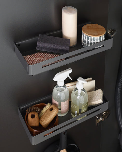 Peka Tablo Libell anthracite hang-on storage trays mounted inside a cupboard door, holding cleaning bottles, brushes and sponges